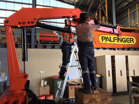 Assembling Palfinger crane during ten-year major inspection.